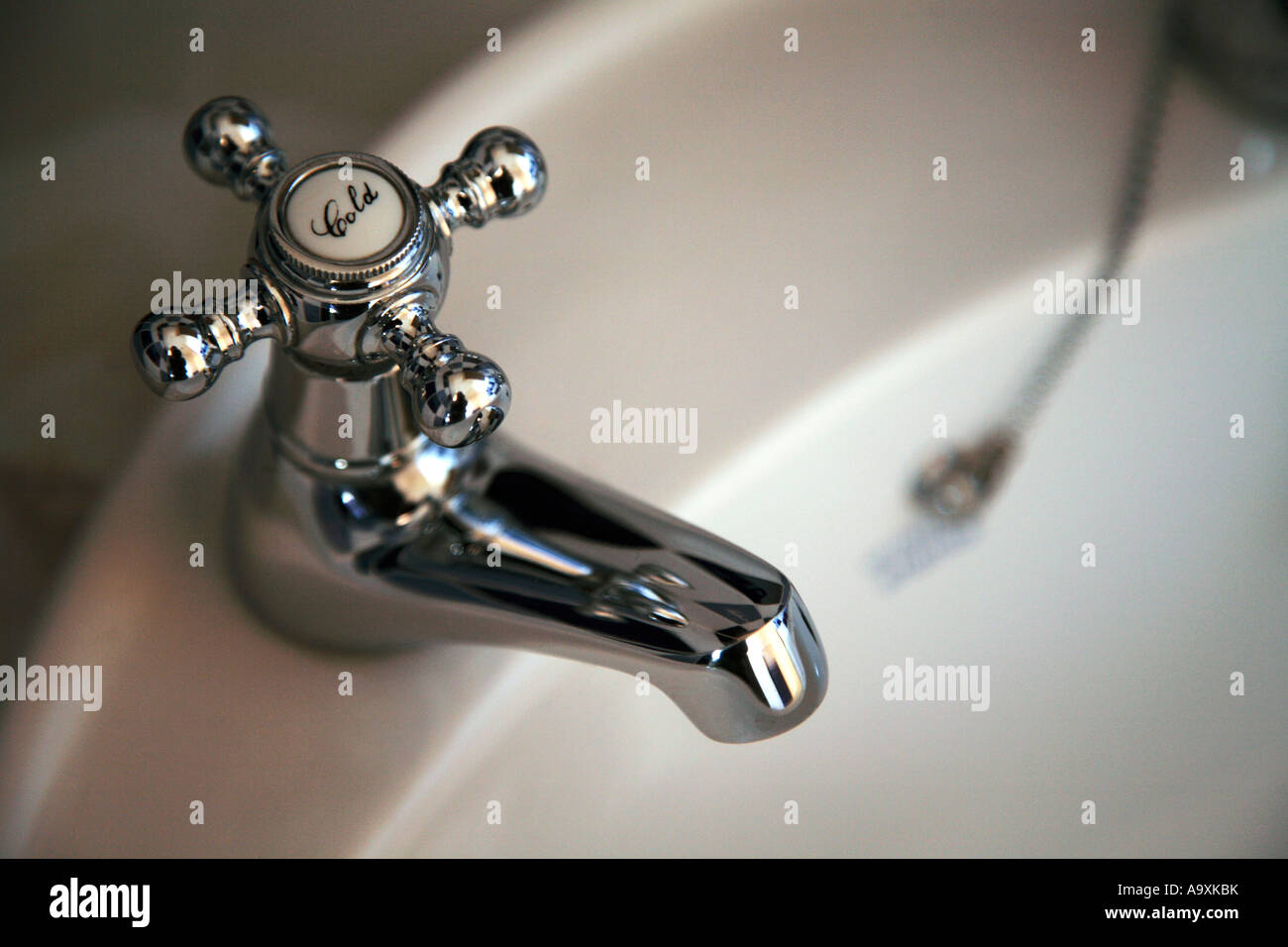 Robinet et évier d'eau froide. Robinet ancien en acier chromé brillant  monté dans un lavabo incurvé Photo Stock - Alamy