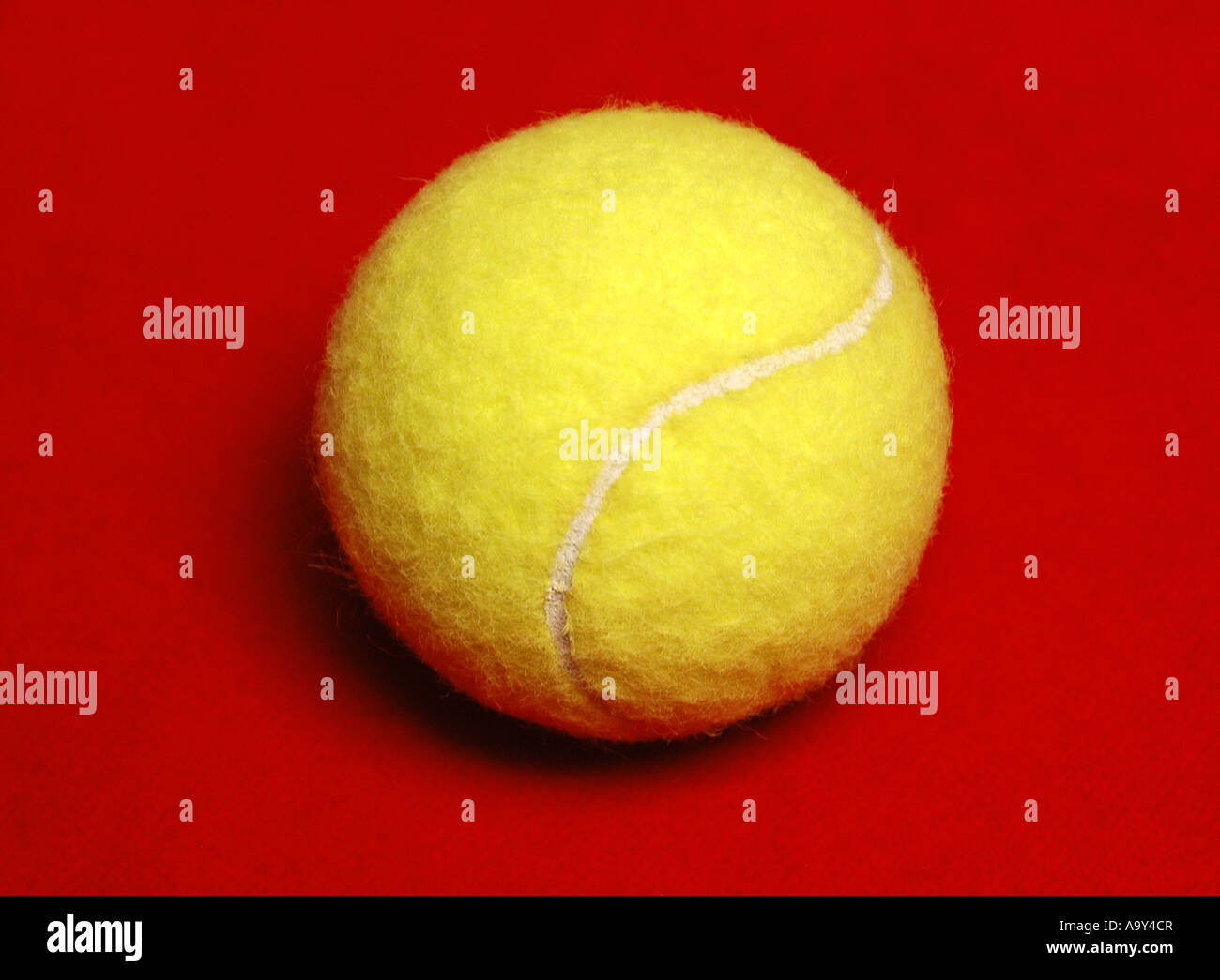Balle de tennis jaune sur fond rouge Banque D'Images