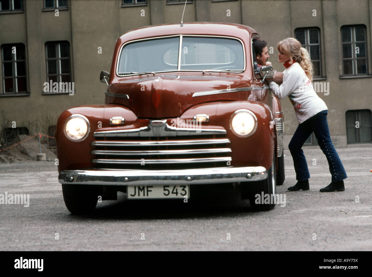 AMERICAN 1960 voiture avec des plaques d'anglais et jeune couple Banque D'Images
