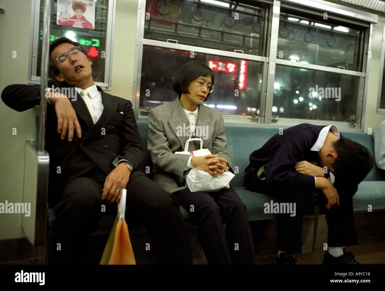 Les gens dormant dans un train de banlieue dans la région de Tokyo Japon Banque D'Images