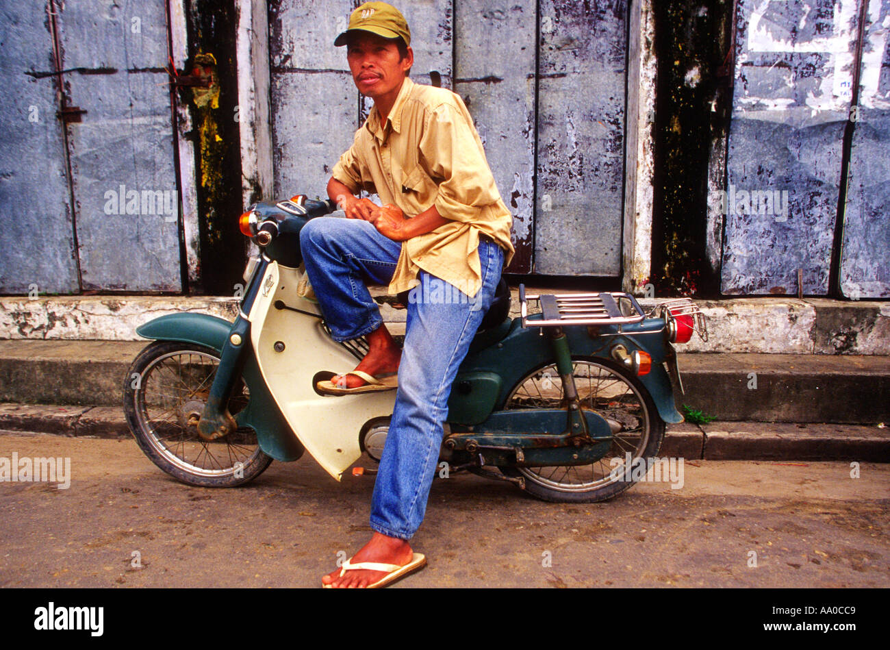 Un jeune homme en pantalon bleu et de tongs assis sur son scooter 50cc  HoiAn Vietnam Photo Stock - Alamy