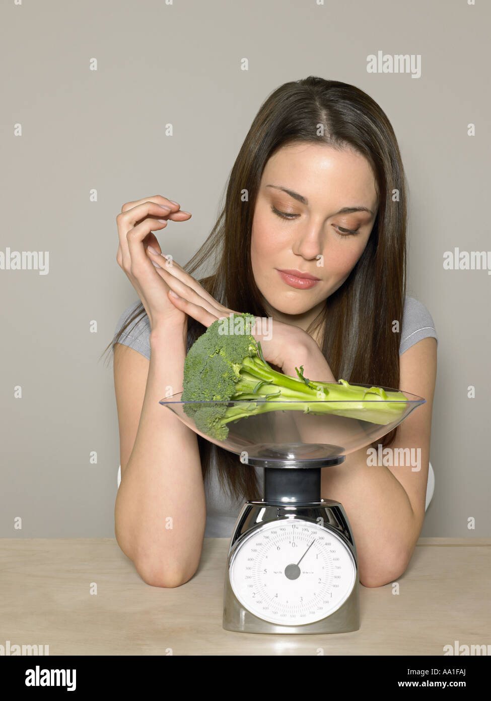 Jeune femme pesant le brocoli Banque D'Images