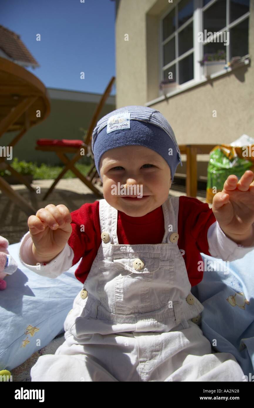 Baby sitting sur terrasse dans jardin Banque D'Images