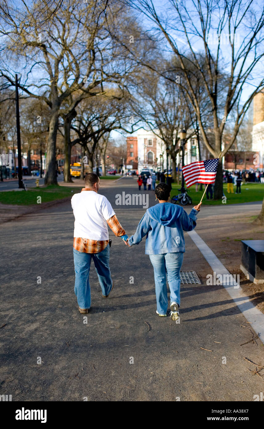 Immigrant américain couple holding US flag passe à l'immigration Rally Banque D'Images