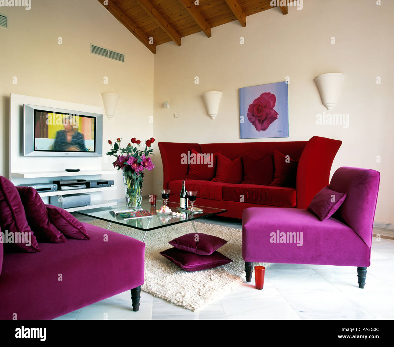 Chaises en velours violet et velours rouge canapé en espagnol moderne salon  avec téléviseur grand écran sur le mur Photo Stock - Alamy