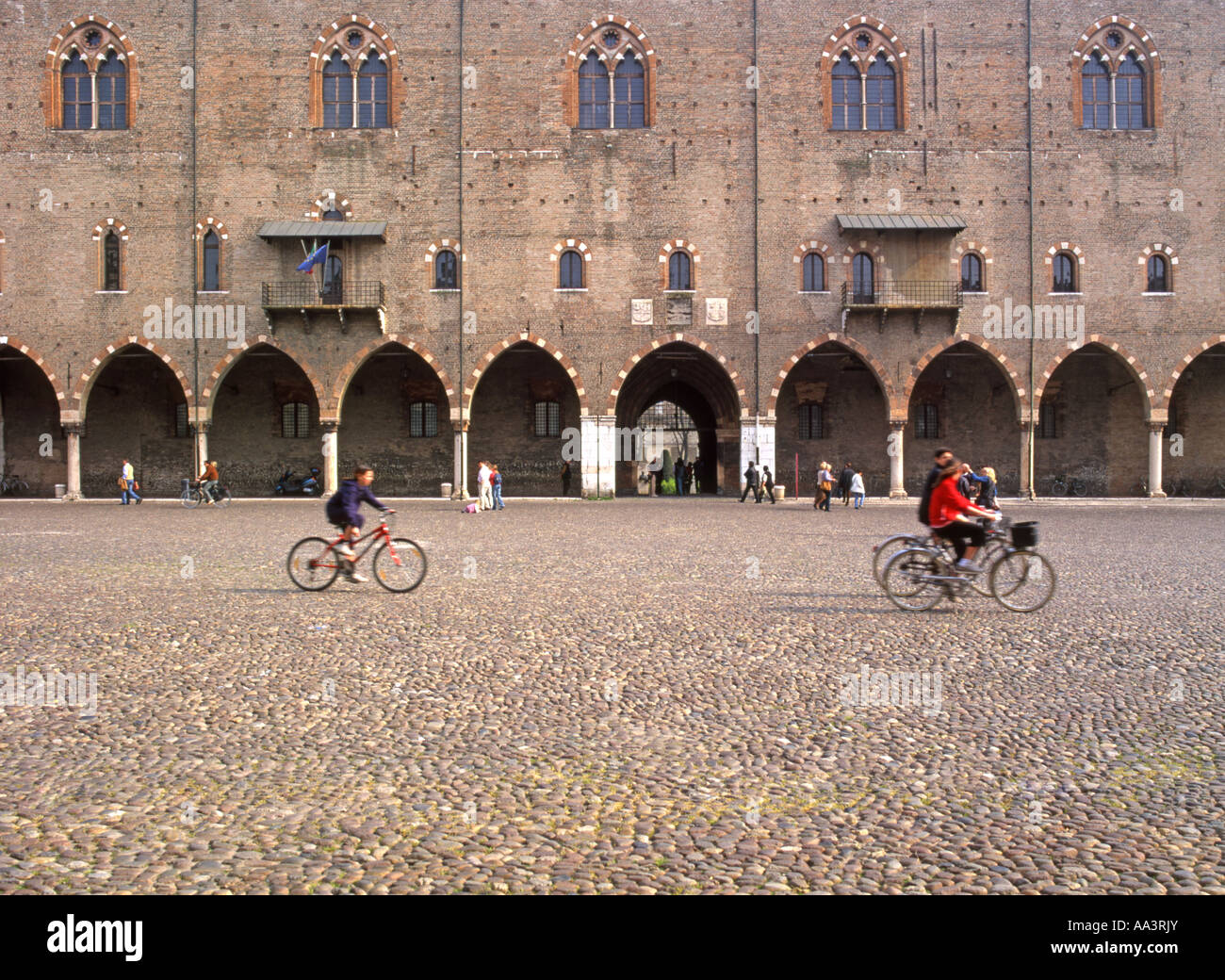 Mantoue, Lombardie, Italie. La Piazza del Erbe. Palazzo della Ragione. Les cyclistes Banque D'Images
