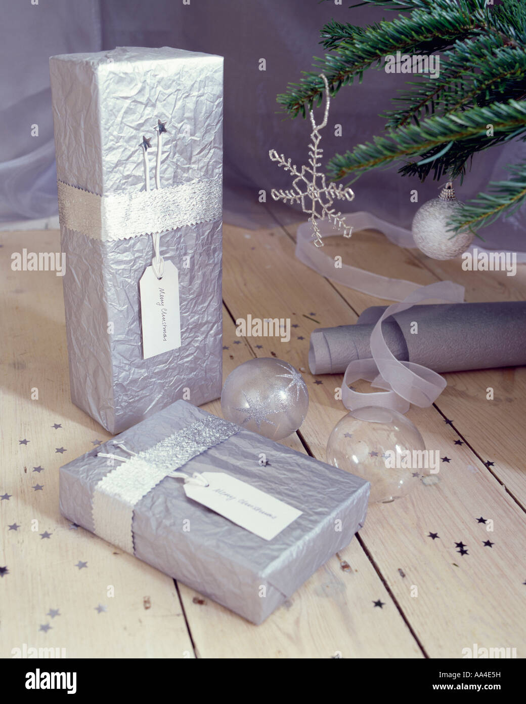 Cadeaux de Noël enveloppé dans du papier de soie argent boules de verre Banque D'Images