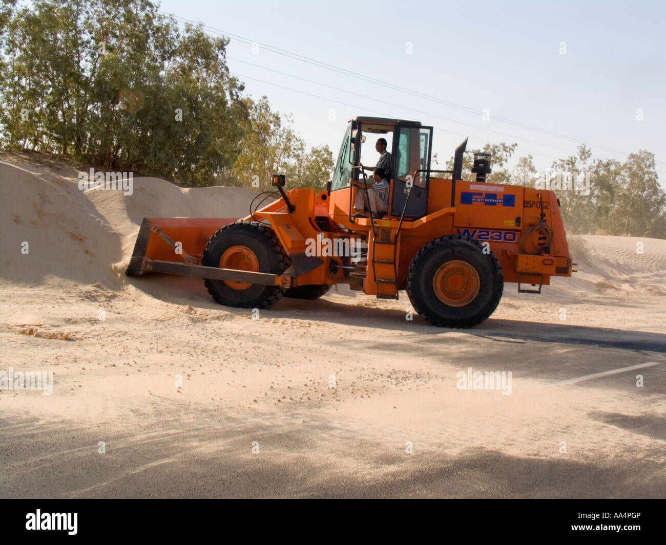 Tracteur efface Sahara sands dérive d'une route principale Tunisie Banque D'Images