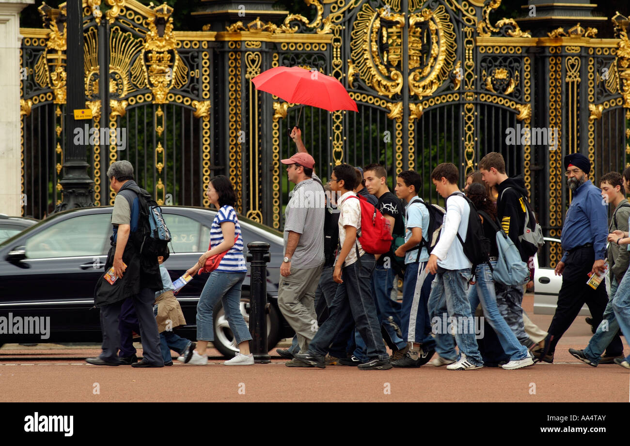 Guide touristique avec parapluie et groupe d'adolescents Central London England UK Banque D'Images