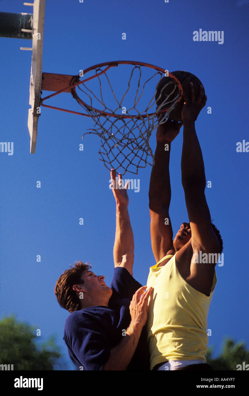 Un joueur tente de la Dunk basket-ball sur son adversaire Banque D'Images