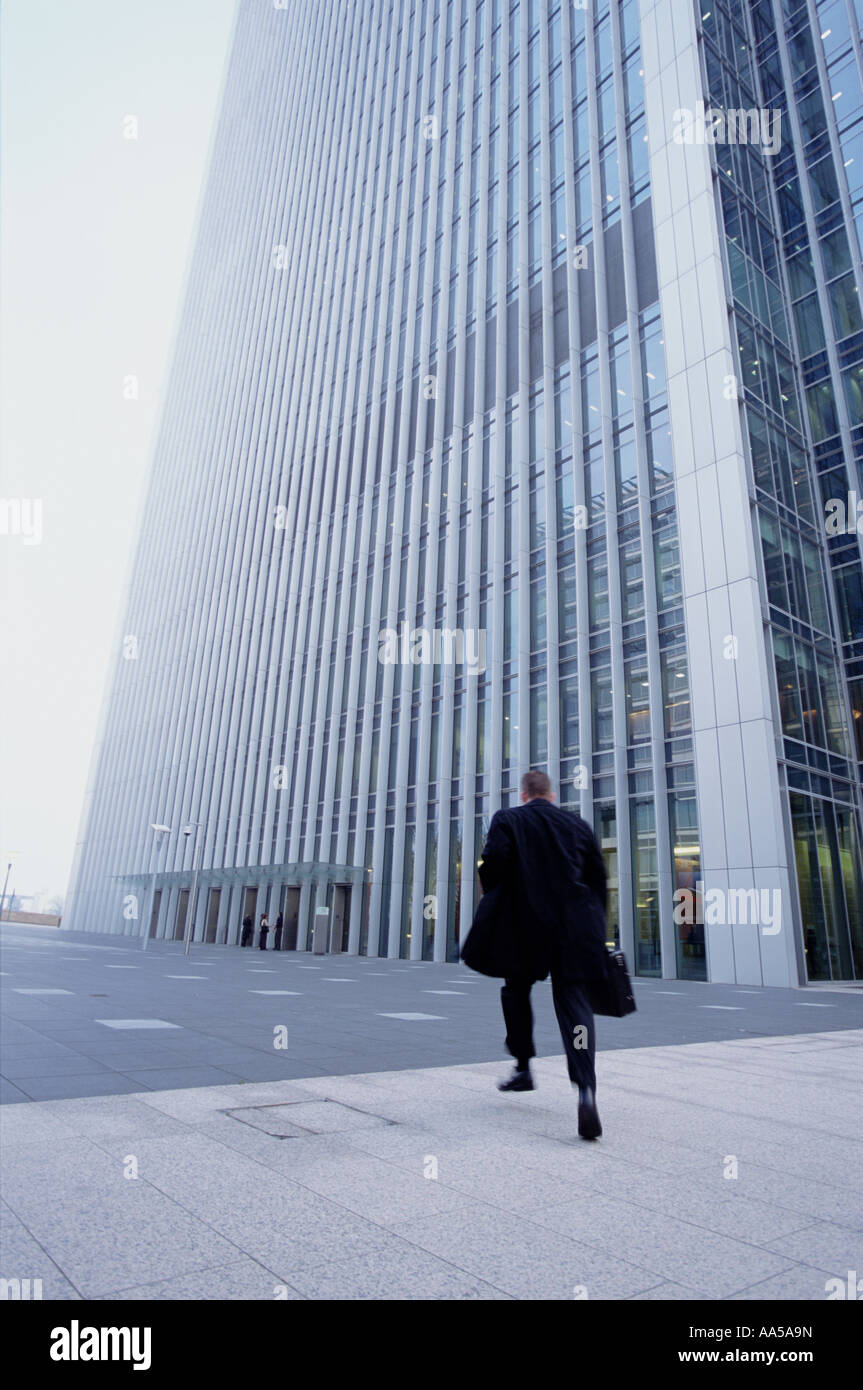 Businessman pressé courir vers le bloc de bureau moderne Banque D'Images