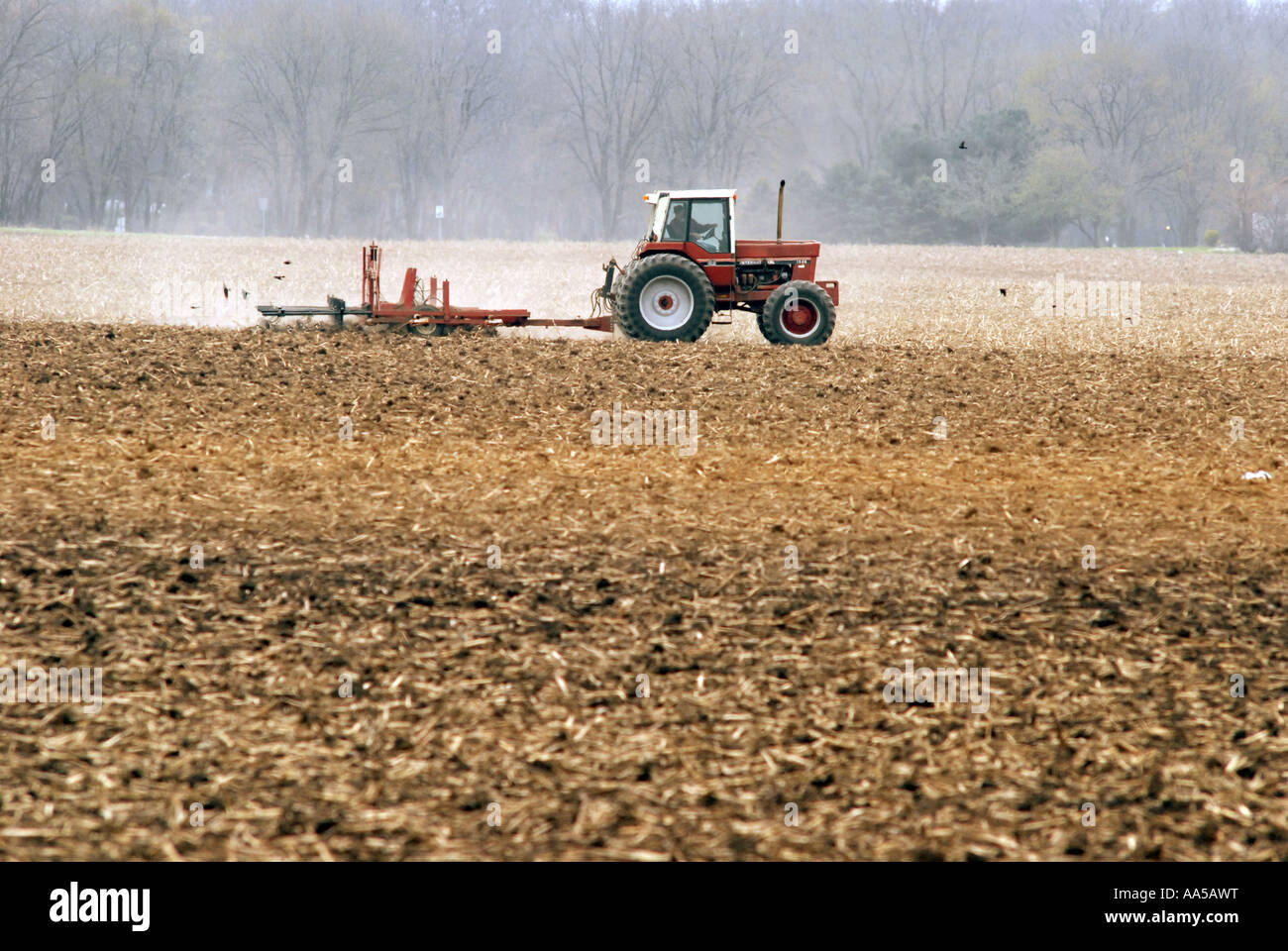 Un agriculteur laboure un champ avant de planter une récolte de maïs dans le midwest des États-Unis Banque D'Images