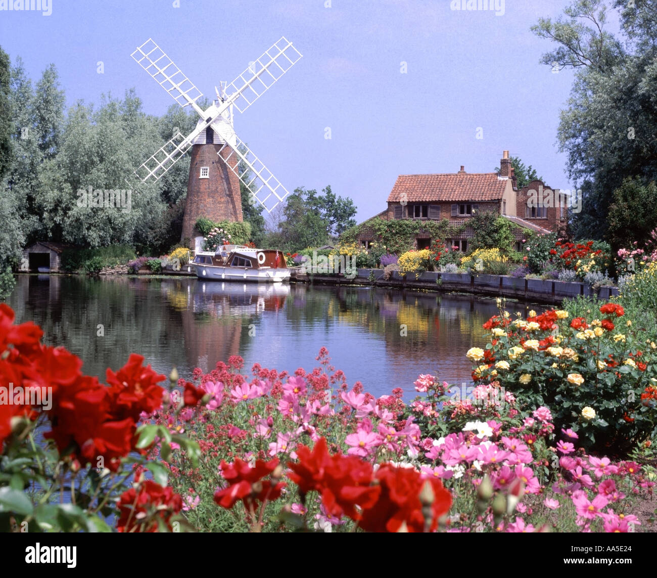 Norfolk Broads bateau amarré à Hunsett Mill moulin & home avec joli jardin d'été au bord de la rivière des fleurs à Stalham Ant East Anglia Angleterre UK Banque D'Images