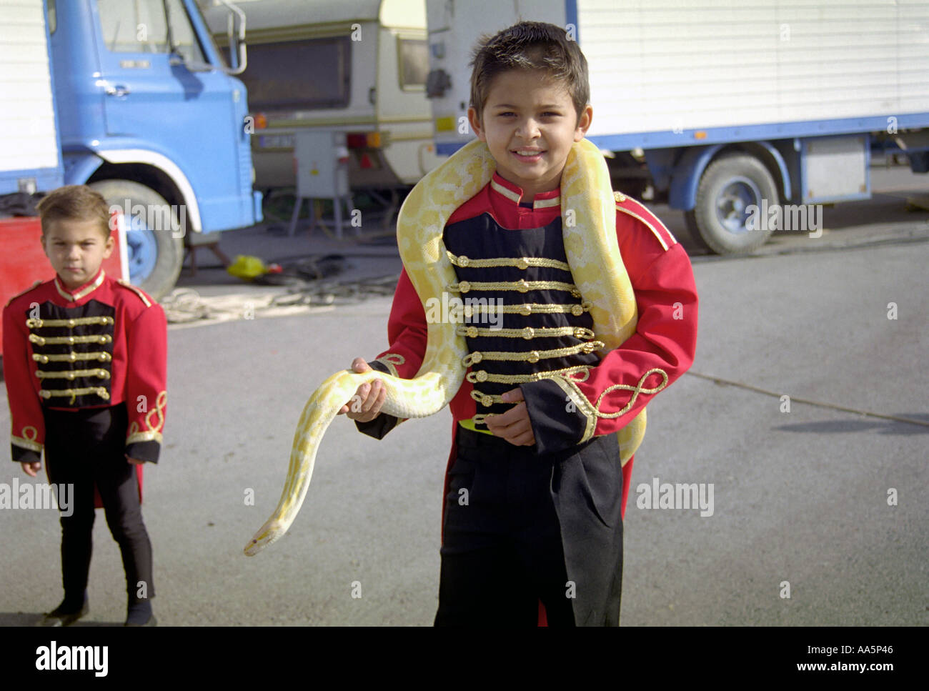 Le garçon avec boa serpent albinos autour de cou Banque D'Images