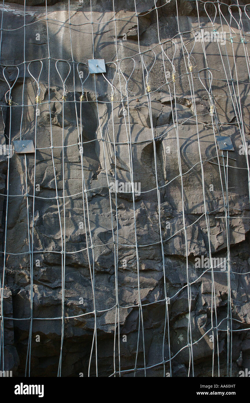 Filet de sécurité de fil acier cloué dans les roches de tenir des roches détachées de la colline Cut raide de passer près de Konkan Railway Alibagh Mumbai Inde Banque D'Images