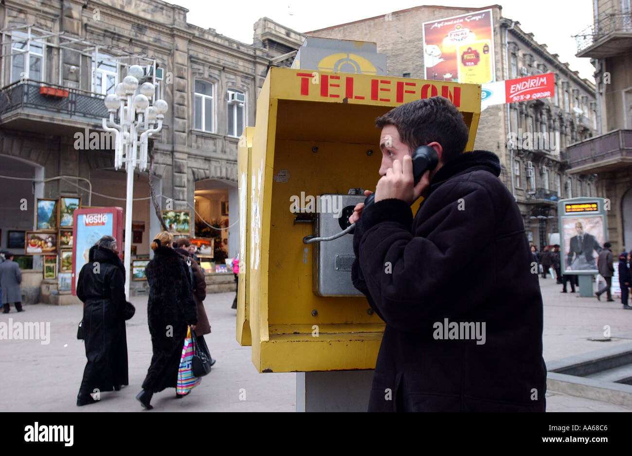 L'Azerbaïdjan Bakou le 11 janvier 2003 Un adolescent azéri fait un appel téléphonique dans le centre-ville de Bakou, où les vendeurs vendent leurs Banque D'Images