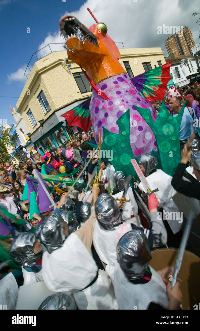 Les enfants de l'école St George habillé comme un dragon attaque pendant la Parade de Childrens, Brighton Festival. Banque D'Images