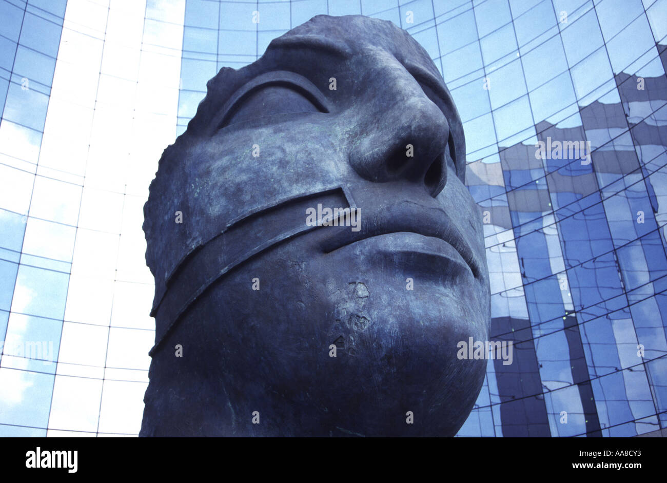 Une sculpture en bronze de Igor Mitoraj regarde sur le verre revêtu gratte-ciel du quartier de la défense de Paris. Banque D'Images