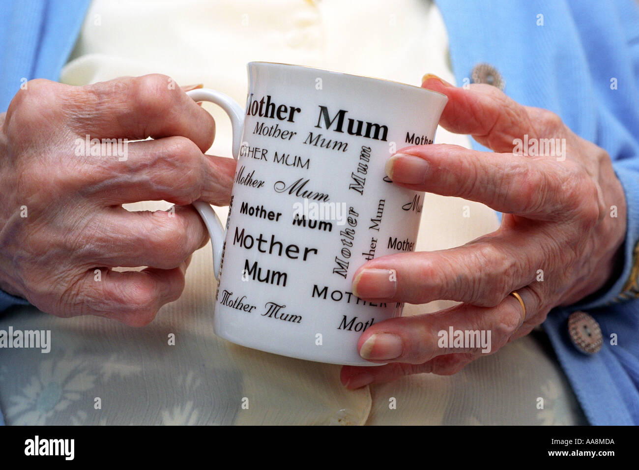 Une vieille dame avec une forme grave d'arthrite tenant une tasse avec les mots maman et mère sur Banque D'Images