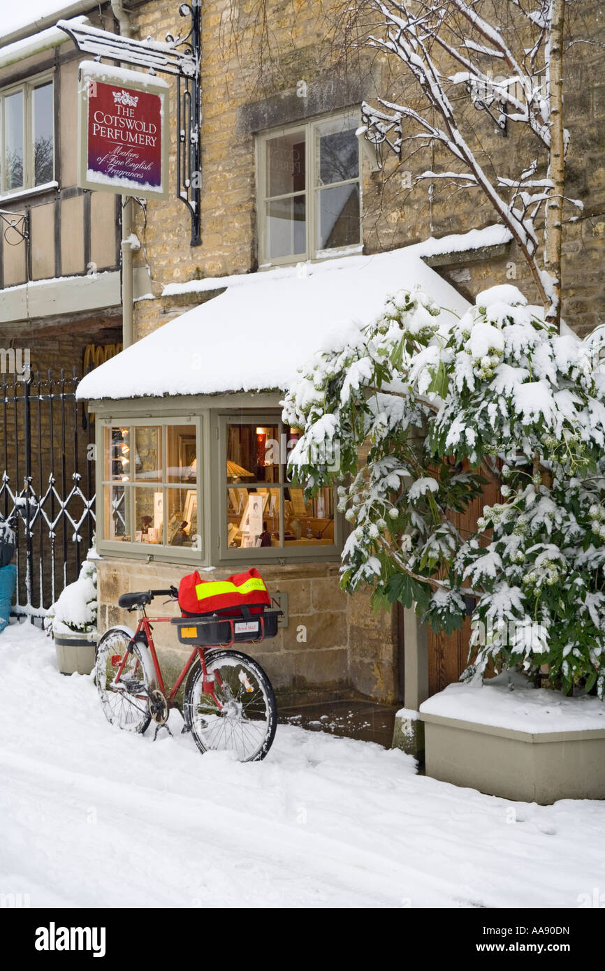 La prestation de la poste lors de neige de l'hiver dans le village de Cotswold Bourton On The Water Gloucestershire UK Banque D'Images