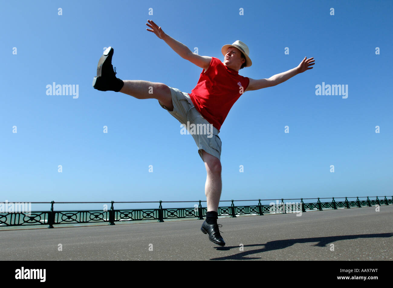 Un excès de middle-aged man doing maladroit kicking élevé danse de routine sur le front de mer de Brighton Banque D'Images