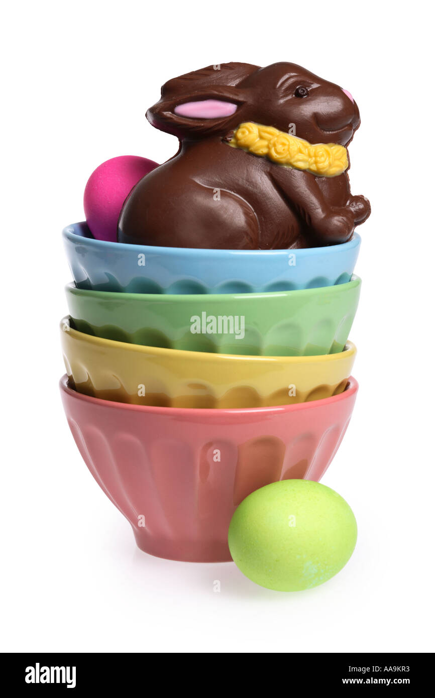 Pile de bols colorés avec du chocolat lapin de Pâques et les oeufs. Banque D'Images