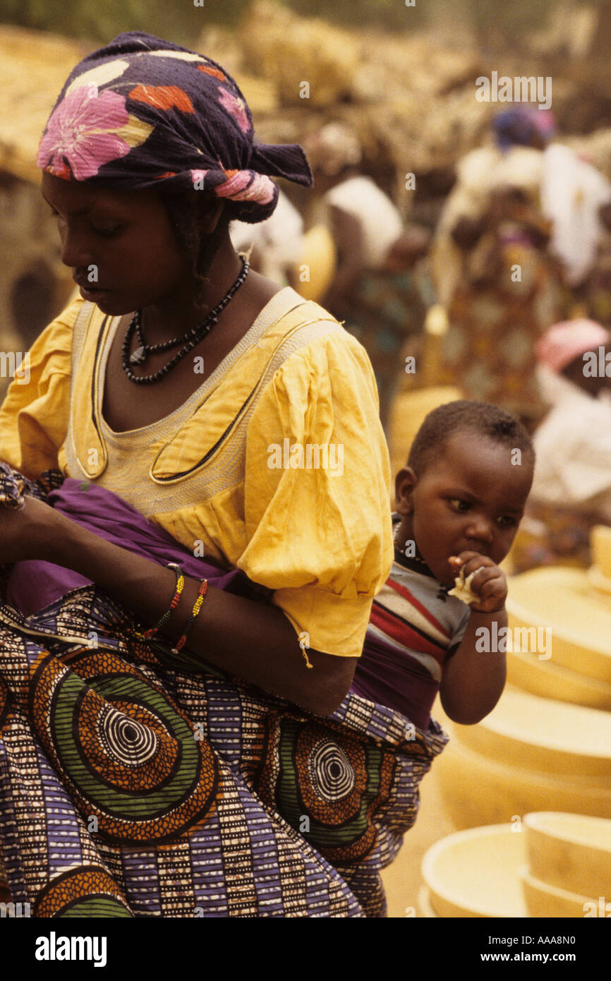 Boubon, près de Niamey, Niger, Afrique de l'Ouest. Mère portant bébé sur retour dans le marché Banque D'Images