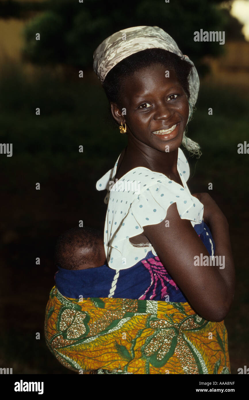 Korhogo, Côte d'Ivoire, Côte d'Ivoire, Afrique de l'Ouest. Jeune fille ivoirienne exerçant son bébé au dos Banque D'Images