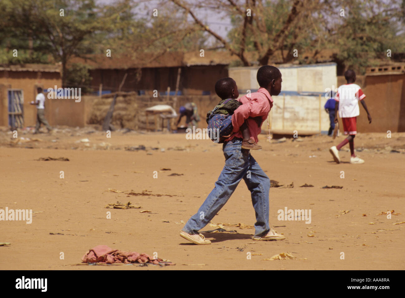 Niamey, Niger, Afrique de l'Ouest. Boy Carrying nigérien du jeune enfant à l'arrière Banque D'Images