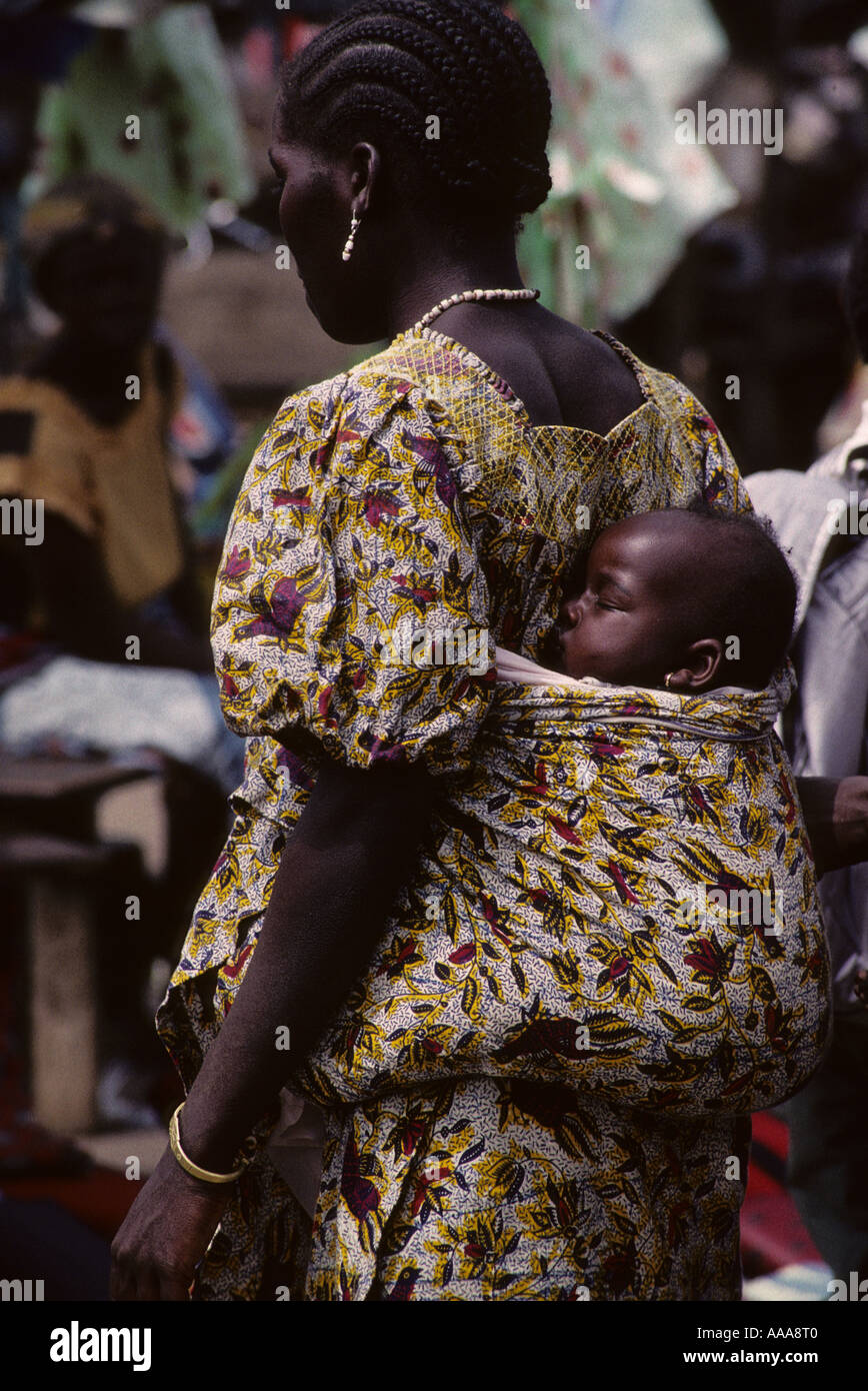Bondoukou, Côte d'Ivoire, Côte d'Ivoire, Afrique de l'Ouest. Mère ivoirienne exerçant son bébé au dos Banque D'Images