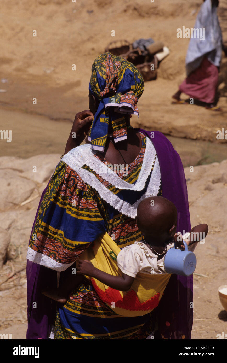 Ayorou, Niger, Afrique de l'Ouest. Mère nigérienne exerçant son bébé au dos Banque D'Images