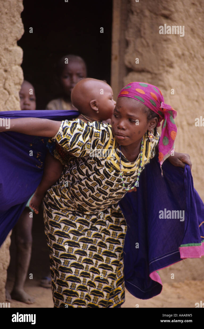 Dan Gaya, Niger, Afrique. Bébé fille rétractable à l'arrière en préparation pour l'exécution Banque D'Images