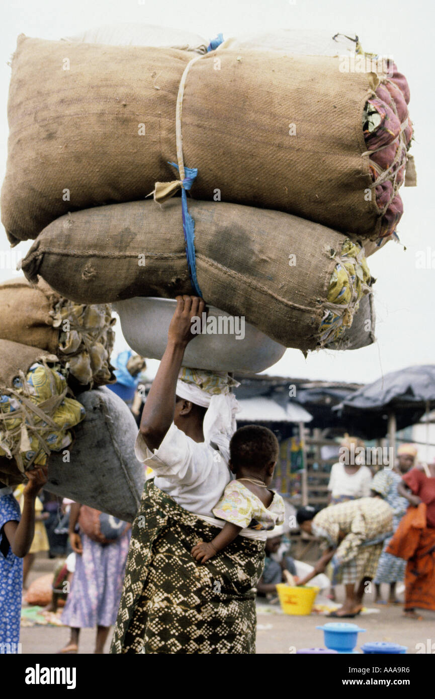 Bondoukou, Côte d'Ivoire, Côte d'Ivoire, Afrique de l'Ouest. Femme ivoirienne des sacs sur la tête, bébé au dos Banque D'Images