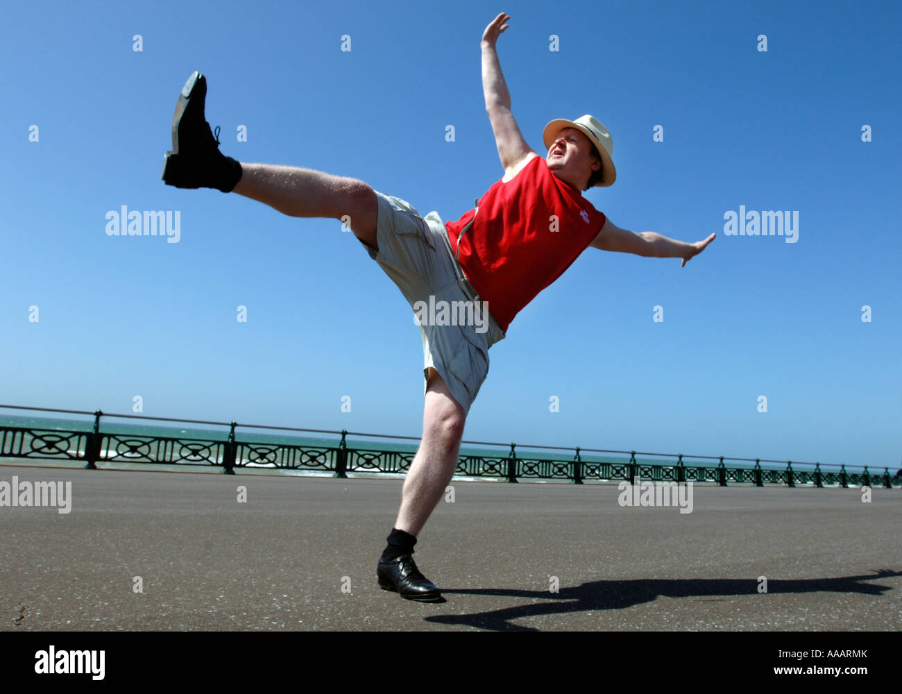 Un homme d'âge moyen surpoids maladroit de faire des coups de danse de routine sur le front de mer de Brighton Banque D'Images