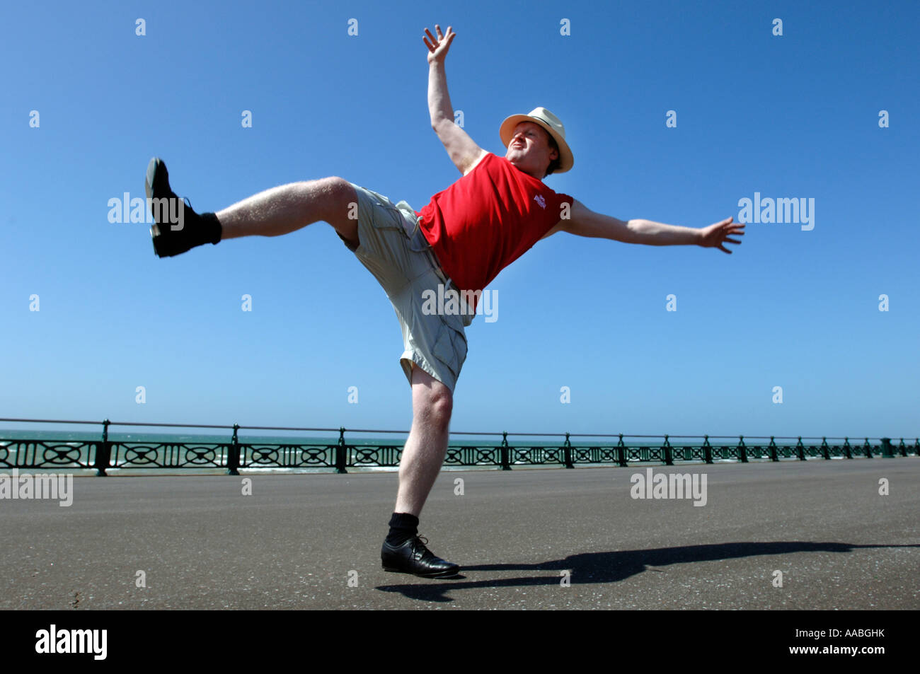 Un homme d'âge moyen surpoids maladroit de faire des coups de danse de routine sur le front de mer de Brighton Banque D'Images