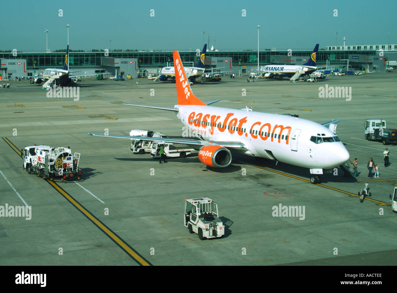 L''aéroport de Stansted EasyJet avion passagers débarqués sans fioritures avec trois avions de Ryanair 3 au-delà sur le béton 'tarmac' Essex England UK Banque D'Images