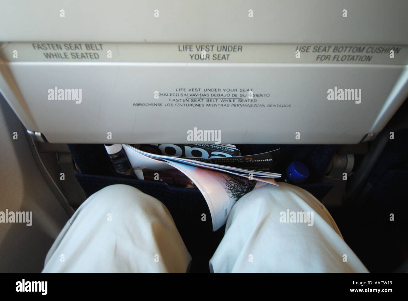 Passagers d'avions genoux près de l'arrière du siège en face illustrant l'espace disponible pour le mouvement et caillot de sang possible problème Banque D'Images