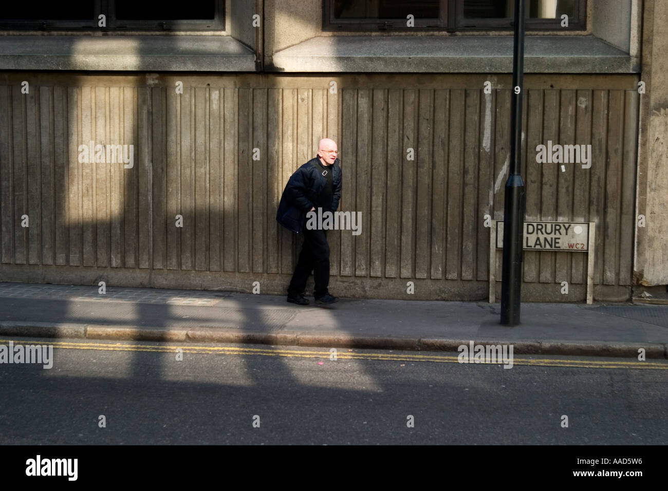 Homme chauve dans la lumière du soleil et l'ombre. Drury Lane, Covent Garden, Londres, Angleterre Banque D'Images