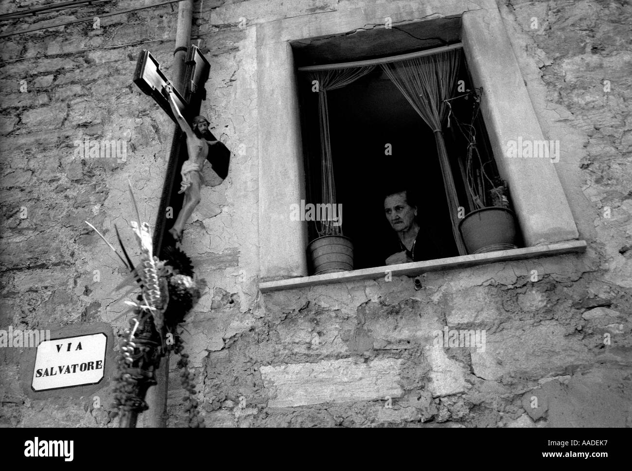 Vieille Femme sicilienne à la fenêtre pendant la procession sainte Gangi Sicile Italie Banque D'Images