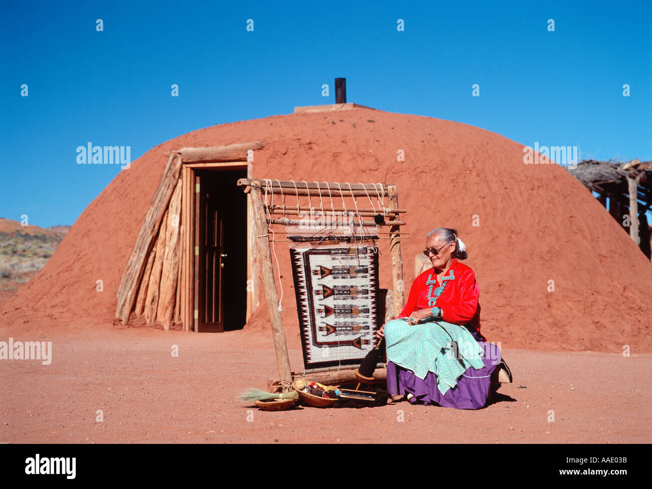 Une vieille femme Amérindienne tisse un tapis Navajo traditionnel à l'extérieur de son hogan dans le nord de l'Arizona Banque D'Images