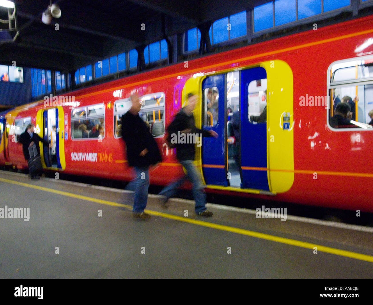 Les banlieusards de se précipiter dans un train, la gare de Waterloo, Londres Banque D'Images