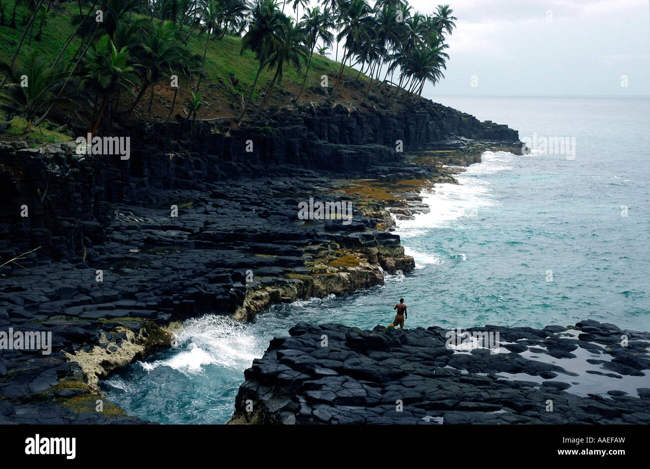 La côte de São Tomé comprend des sections rocheuses magnifiques qui attirent les pêcheurs Banque D'Images