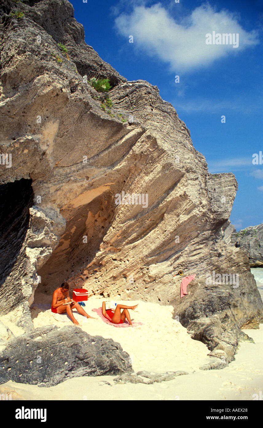 Les Bermudes La géologie historique plage rose couple relaxing on beach under rock formation Banque D'Images