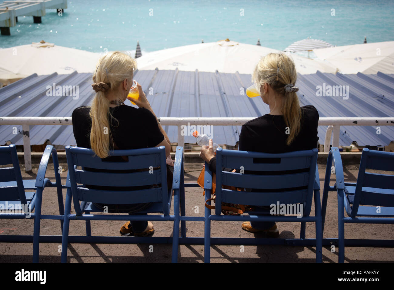 Deux sœurs de boire le jus d'orange sur le front de mer, Promenade des Anglais, Nice France. Utilisez UNIQUEMENT ÉDITORIALE Banque D'Images