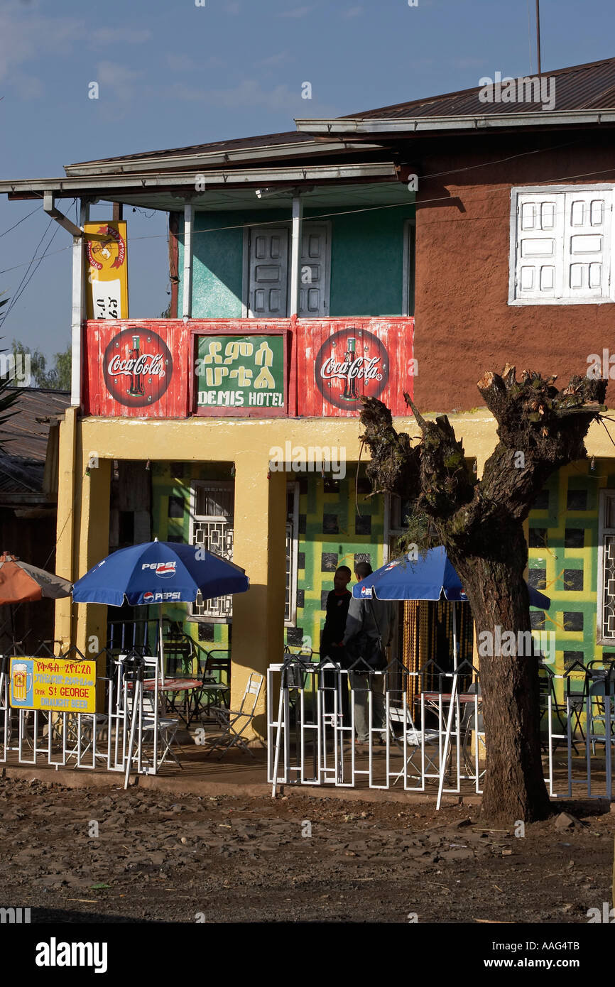 Hommes debout à l'extérieur de l'atelier avec Coca Cola signes dans village de Dejen près de Shafartak Afrique Ethiopie pont Banque D'Images