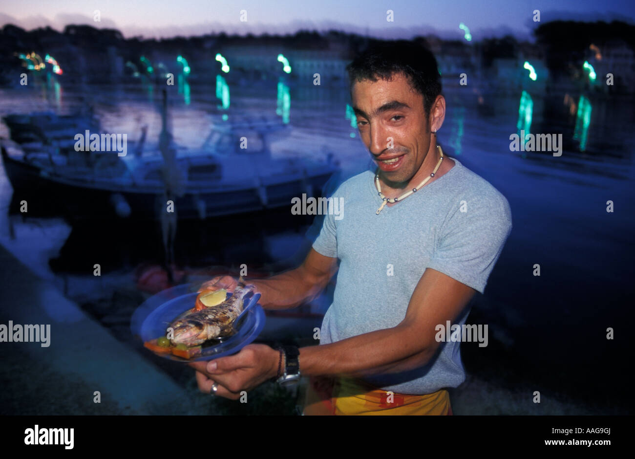 L'homme de servir du poisson Bife Toni Sali Croatie Dalmatie île de Dugi Otok Banque D'Images