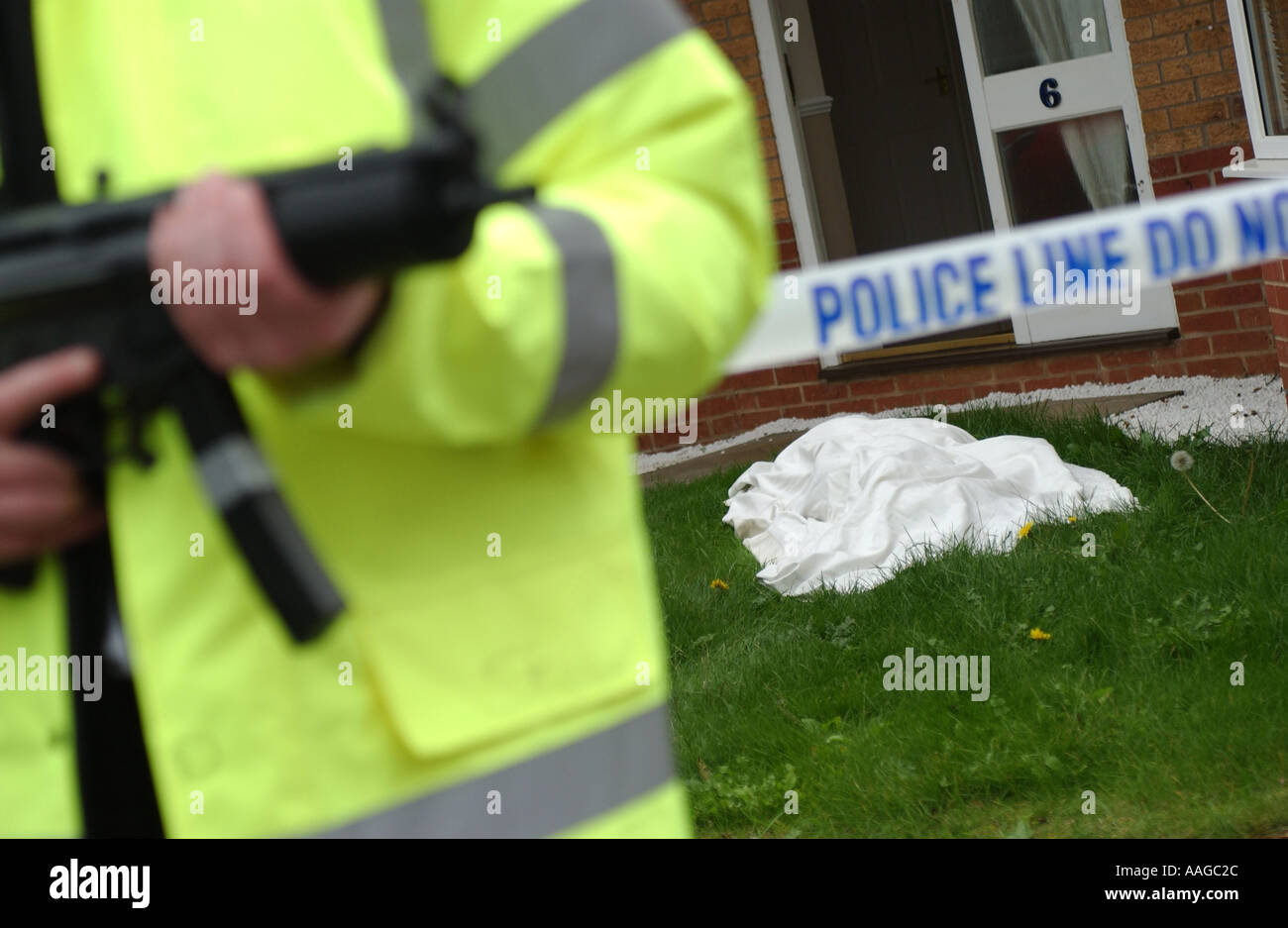 Un officier de police dans une veste réfléchissante tenant un Heckler et Koch MP5 machine gun à un crimescene Banque D'Images