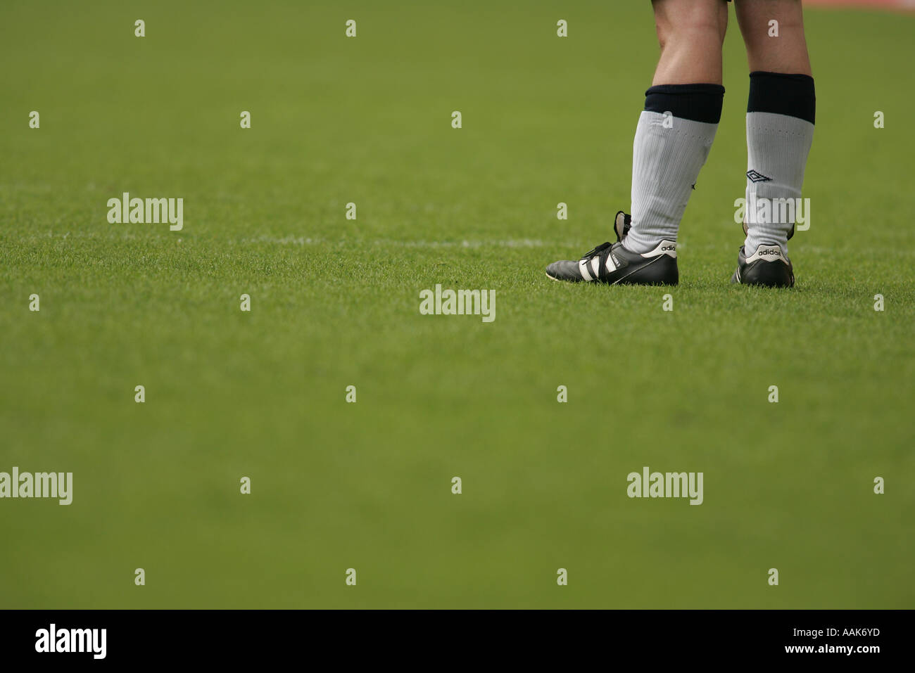 Close up of football players pieds était encore avec des bottes noires chaussettes blanches Banque D'Images