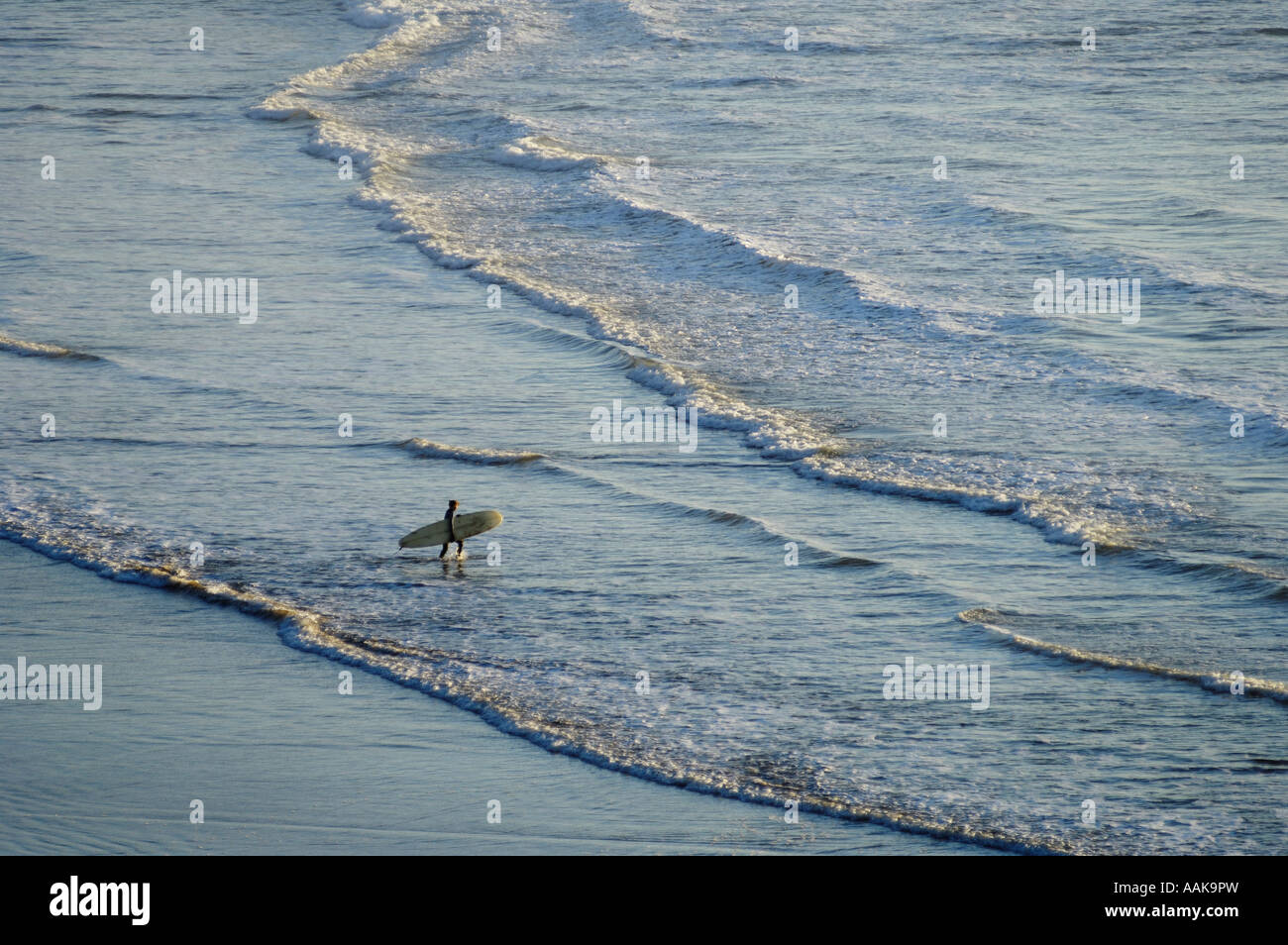 Femme avec la position de surf sur les vagues de Indian Beach au parc d'état d'Ecola sur le Nord de la côte de l'Oregon Banque D'Images