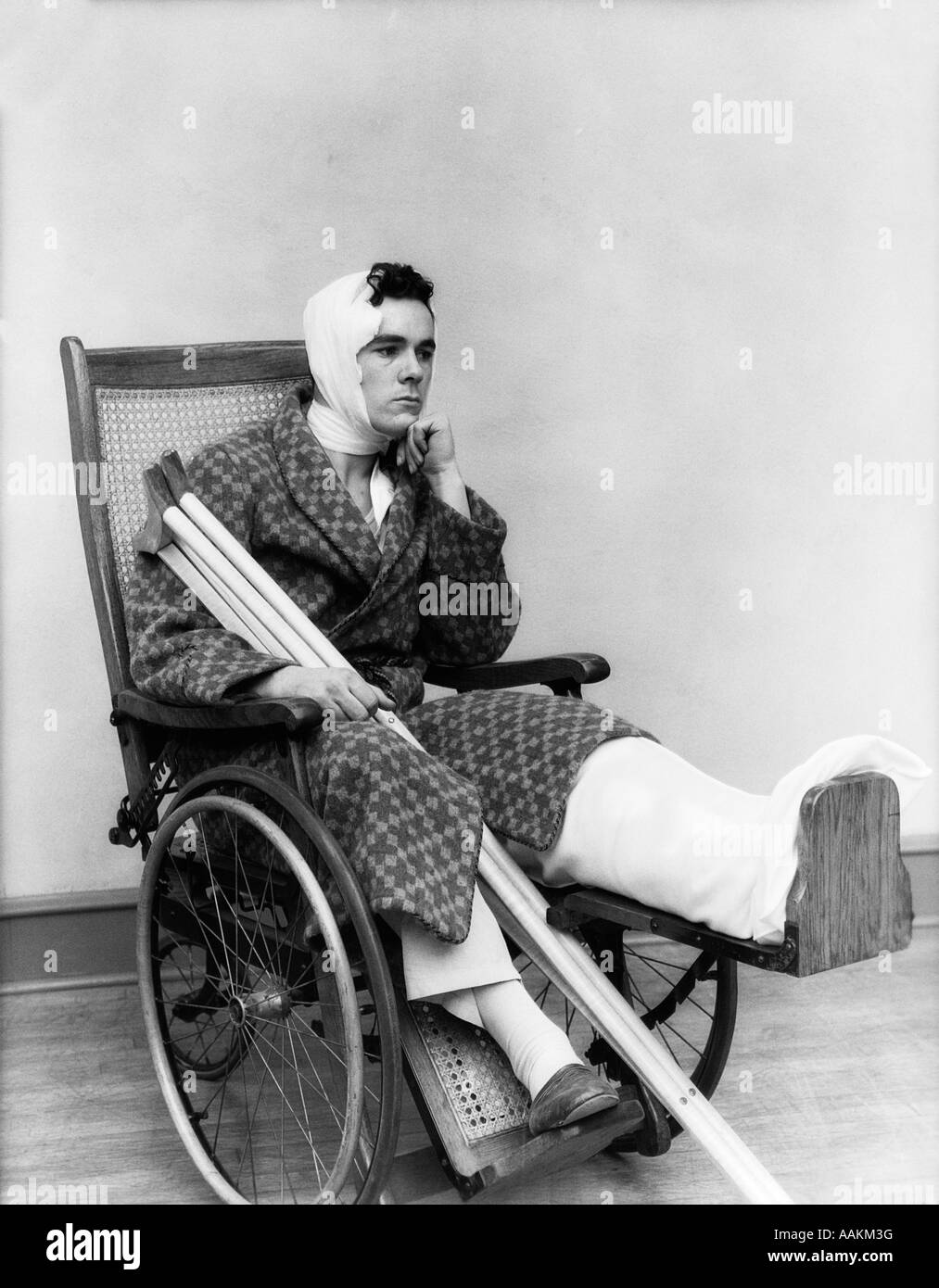 1930 MAN IN WHEELCHAIR LEG CAST BÉQUILLES COU TÊTE BANDAGE Banque D'Images